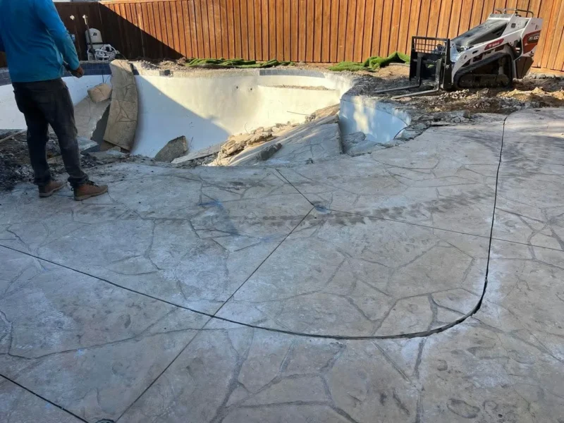 Curved cut separating the retained patio from demolition