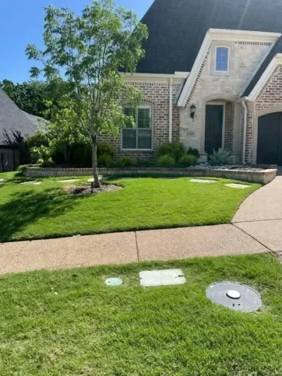 Installed front lawn beside stone landscape beds