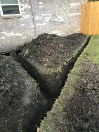 Yard drainage excavation beside house: work in progress, view 1