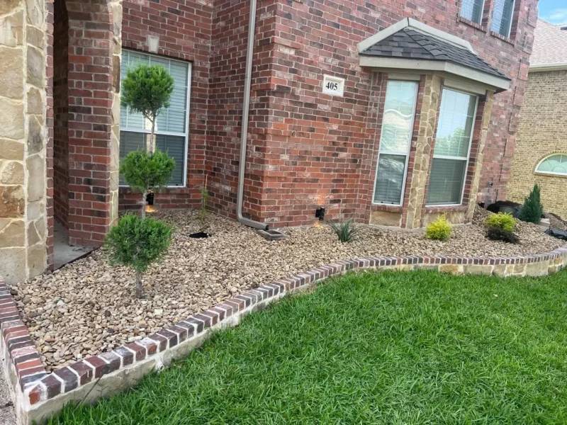 Stone flowerbed edging with brick cap and river rock beds &middot; view 3