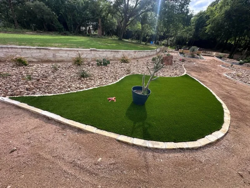 Artificial turf island surrounded by stone edging and rock beds