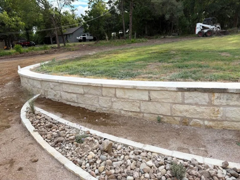 Curved stone retaining wall and rock bed border