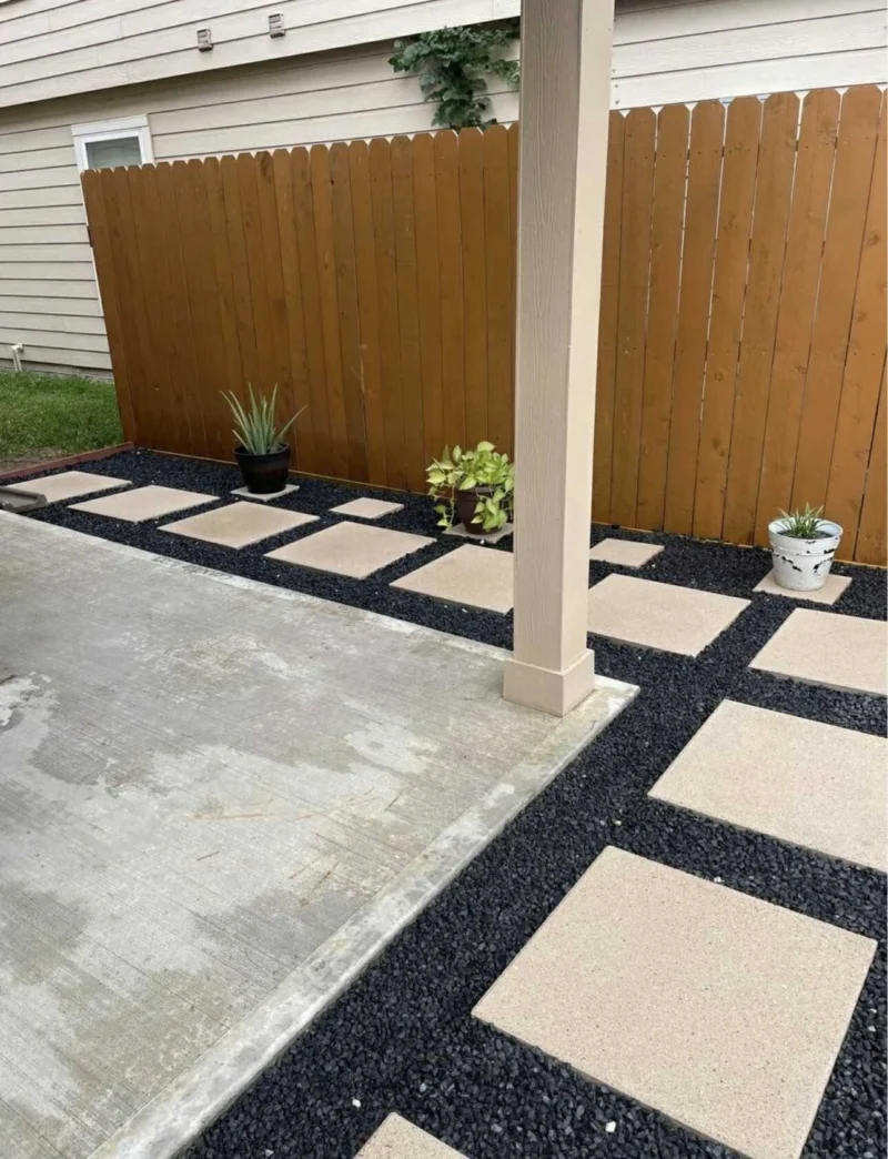 Concrete stepping stones with black DCG along the patio edge.