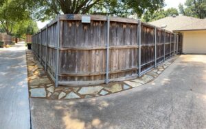 Wide view of a flagstone and DCG pathway wrapping around an existing fence beside the back alley