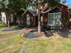 Front yard with Benda Board edging, river-rock tree rings and planted flowerbeds