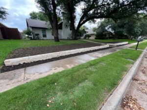 Wide view of the completed Austin stone retaining wall following the sidewalk