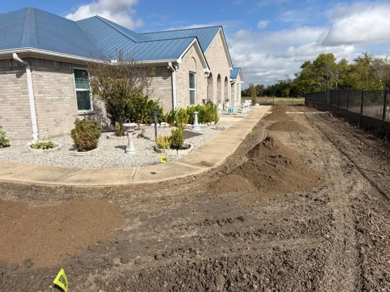 The cleared lawn area with soil staged for spreading.