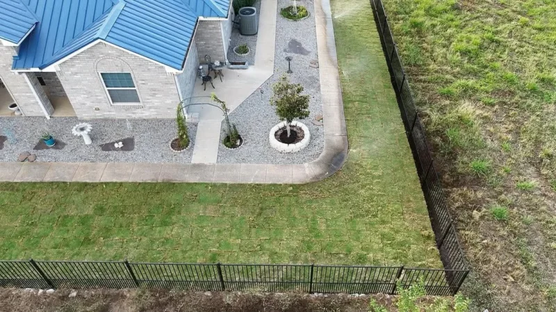 Fresh sod fitted around the walkway, with watering underway.
